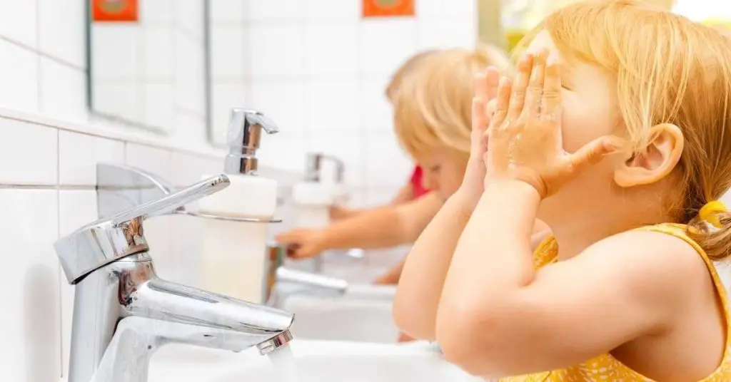 kids washing their faces and hands