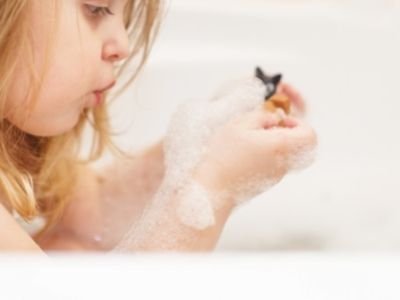 little girl playing bath treasure hunt in the bathtub