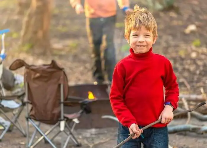 A little boy camping which is a great naturalistic intelligence activity